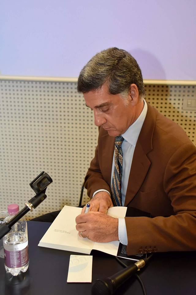 Marco Tullio Barboni mentre firma autografi